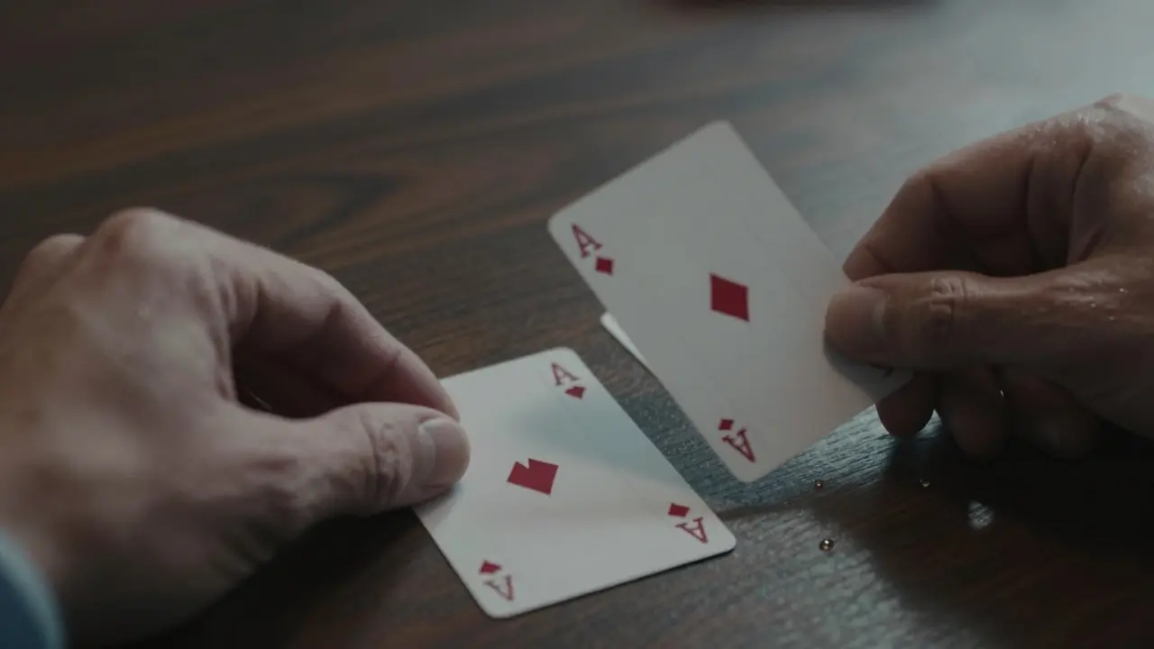 Manos realizando un truco de cartas con precisión, una carta flotando ligeramente sobre la mesa.